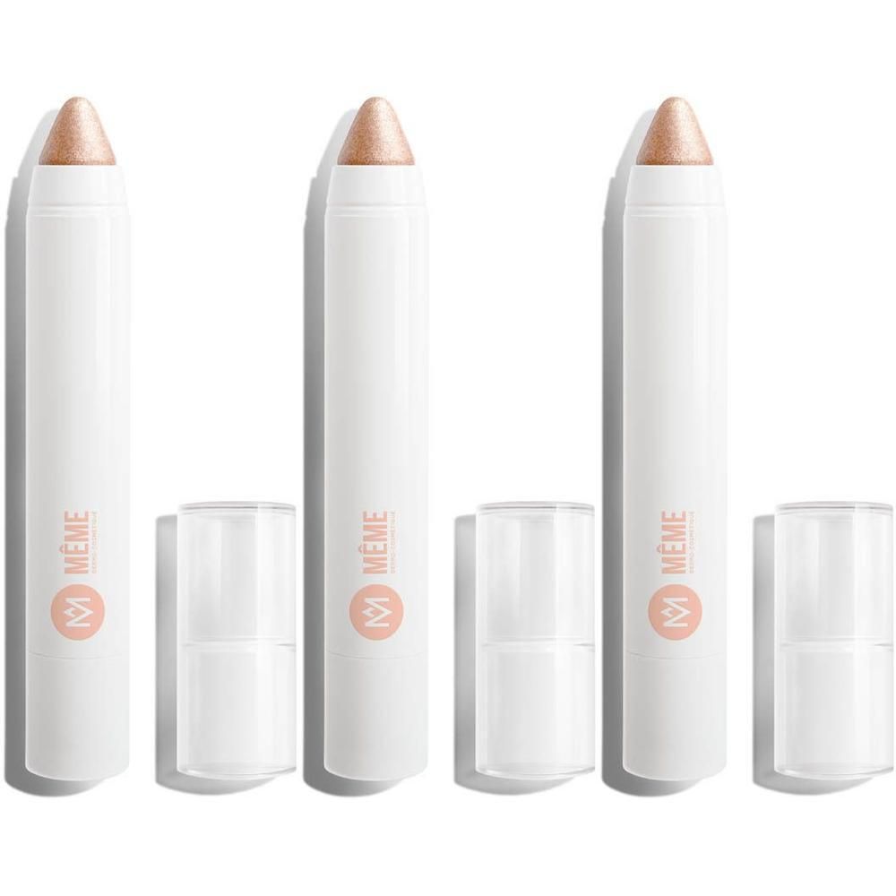 Drie witte stiften met gouden oogschaduw. Doppen verwijderd. Logo "Même".