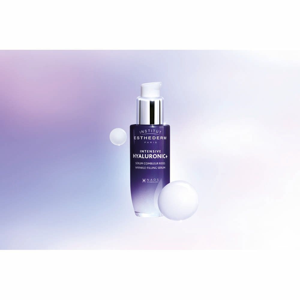 Serumfles met zilveren pompkop. Donkerblauwe fles. Opschrift: Institut Esthederm, Intensive Hyaluronic+. Twee witte bollen.