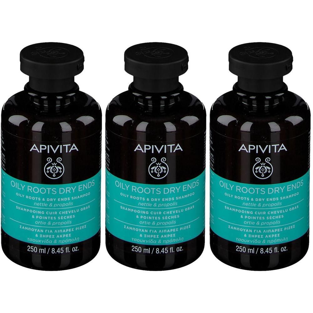 Trois flacons de shampooing. Flacons noirs avec bouchons noirs et étiquettes turquoise. Inscription : APIVITA, OILY ROOTS DRY ENDS.