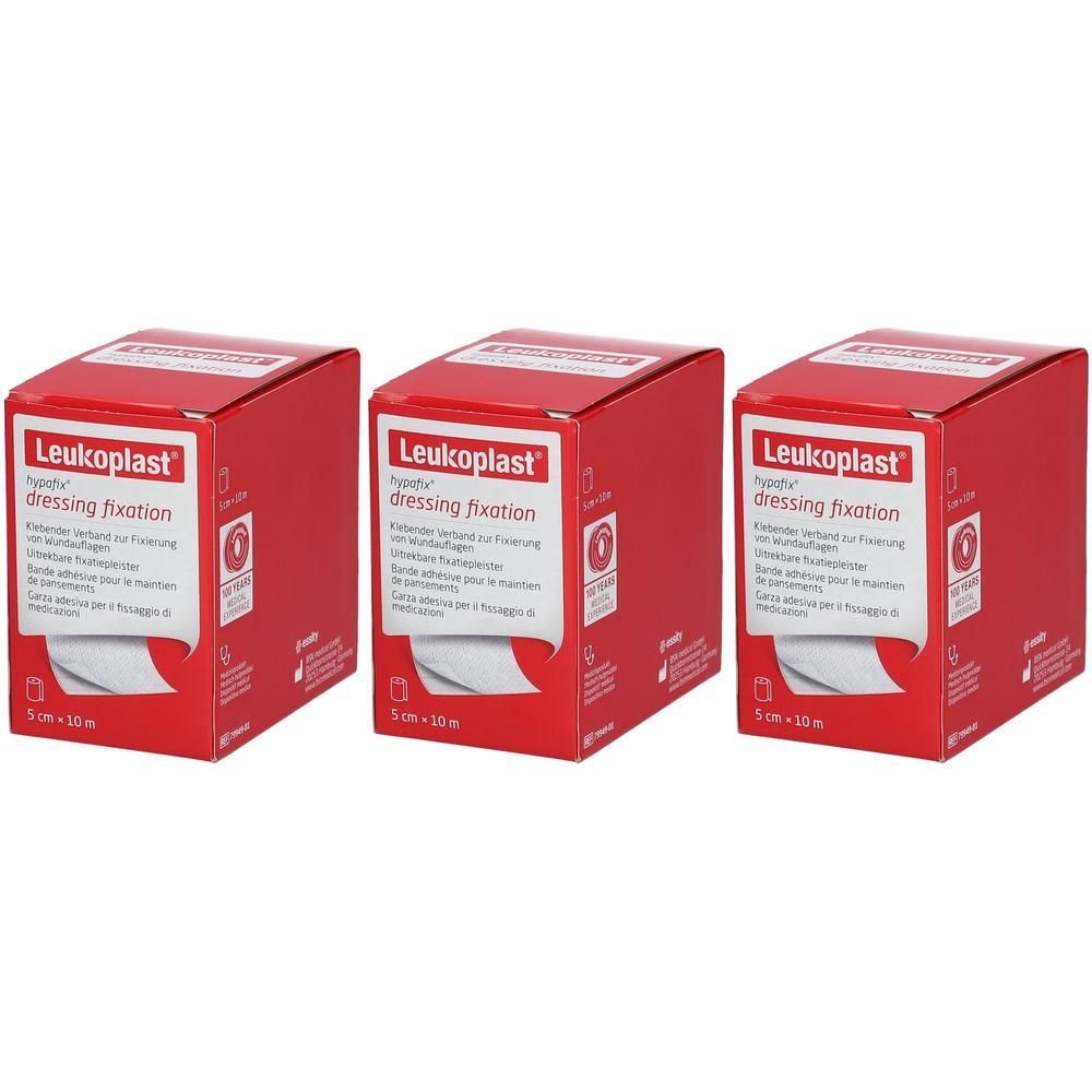 Trois boîtes rouges de Leukoplast® Hypafix. Inscription : dressing fixation, 5 cm x 10 m. Matériau de pansement blanc visible.