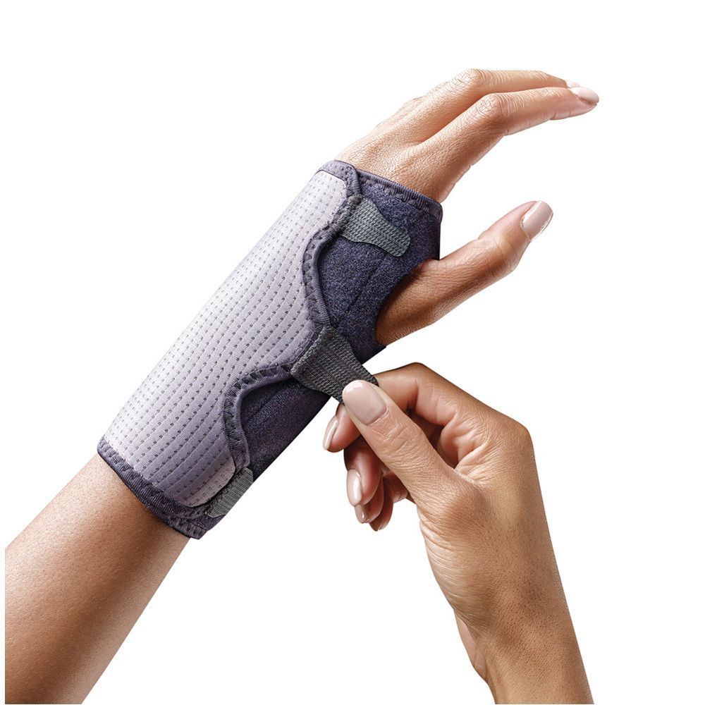 FUTURO™ polsbrace op een hand. Persoon bevestigt klittenbandsluiting. Grijs en zwart.