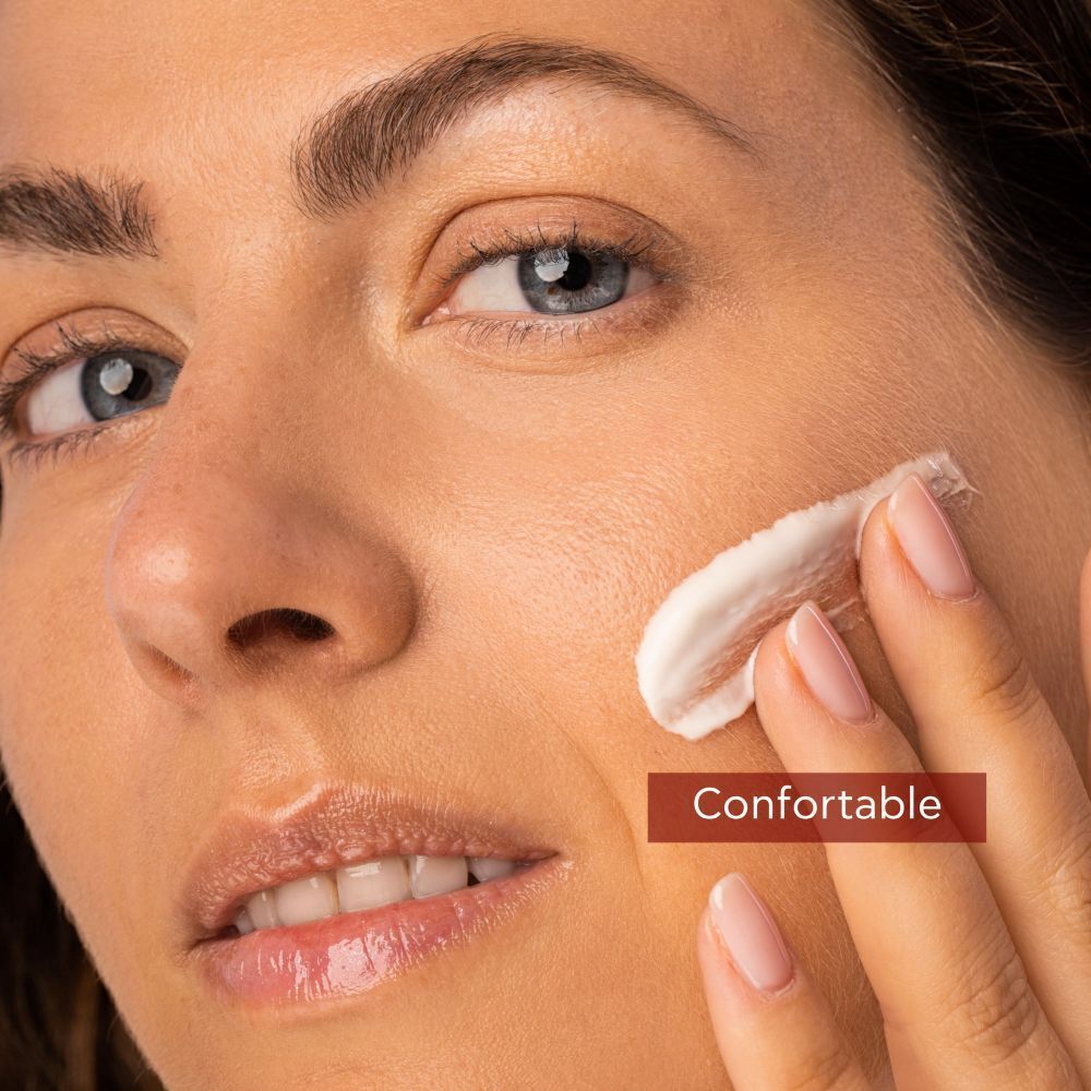 Femme appliquant de la crème. Texte: Confortable. Sur fond rouge.