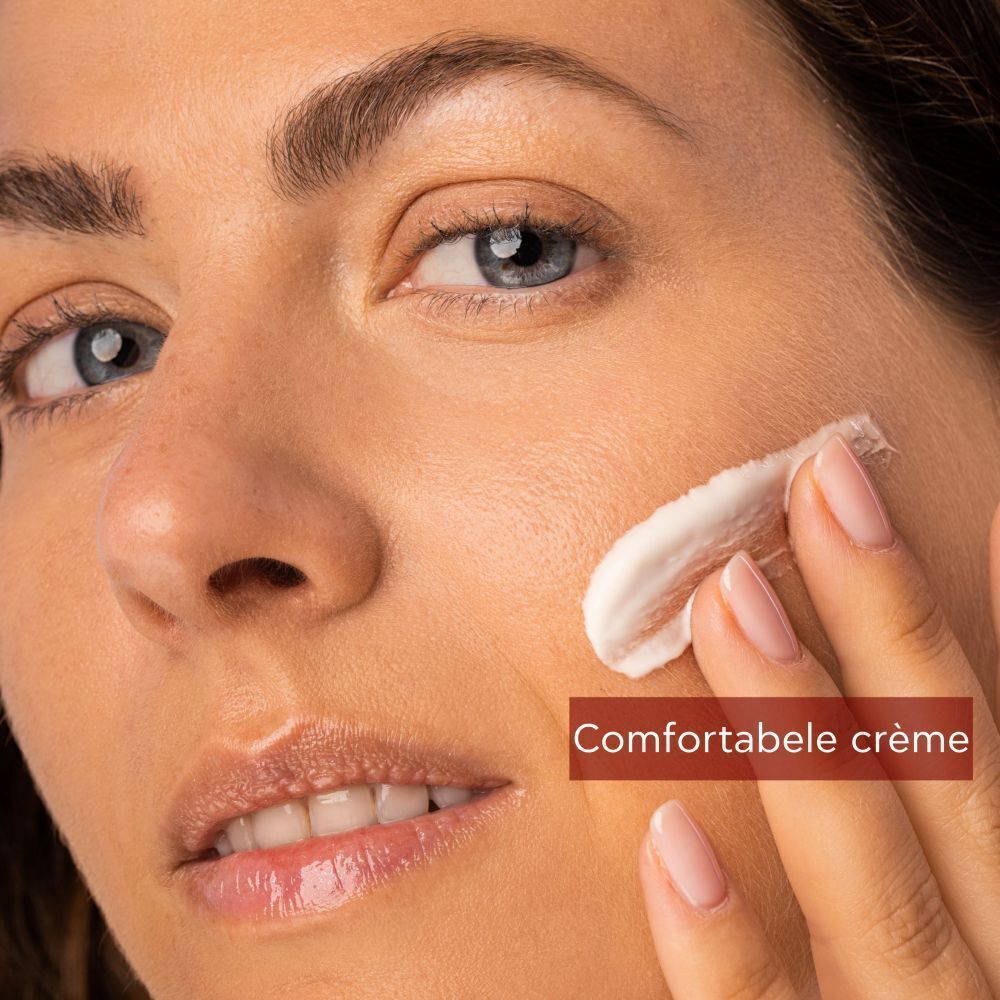 Vrouw brengt crème aan. Tekst: Comfortabel. Op rode achtergrond.