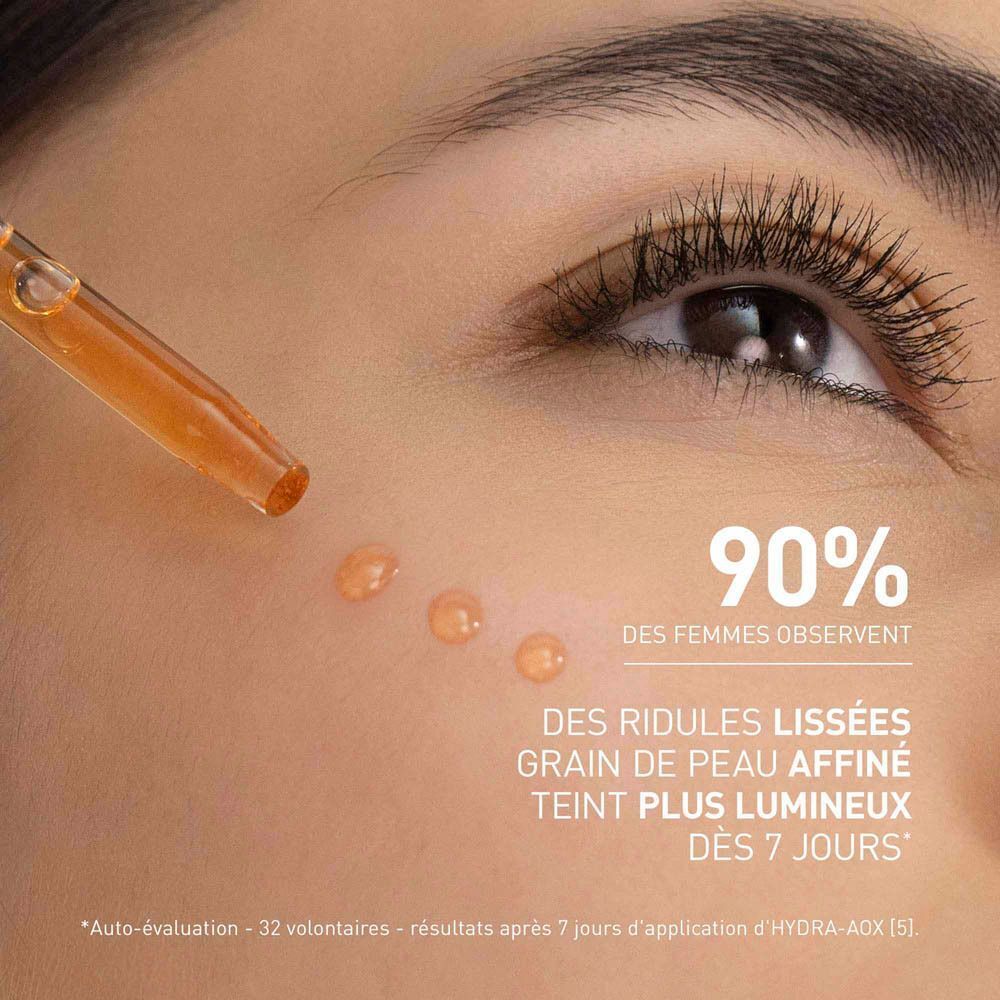 Gros plan sur un œil avec des gouttes de sérum. Texte: 90% DES FEMMES OBSERVANT DES RIDULES LISSÉES.