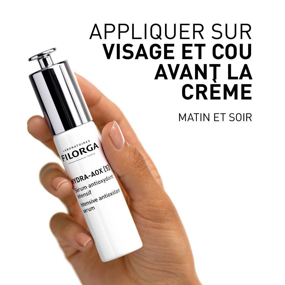Main tenant une bouteille de sérum Filorga HYDRA-AOX [5]. Texte: APPLIQUER SUR VISAGE ET COU AVANT LA CREME.