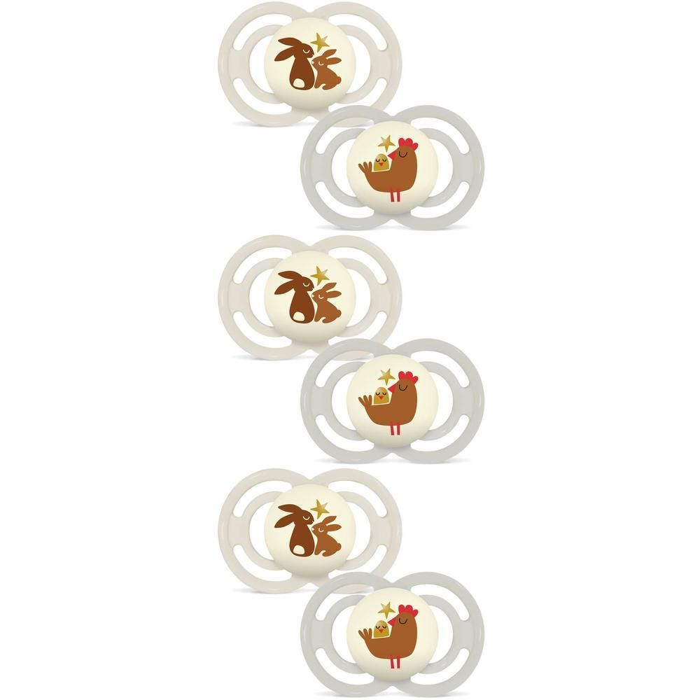 Trois emballages de sucettes. Chaque emballage contient deux sucettes, une verte et une crème. Emballage avec nom du produit et recommandation d'âge.