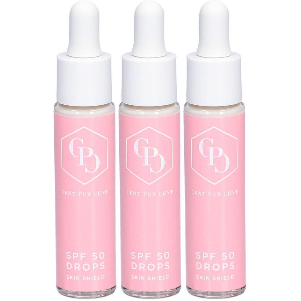 Trois flacons avec étiquettes roses. Inscription : Cent Pur Cent SPF 50 Drops. Bouchons compte-gouttes blancs.