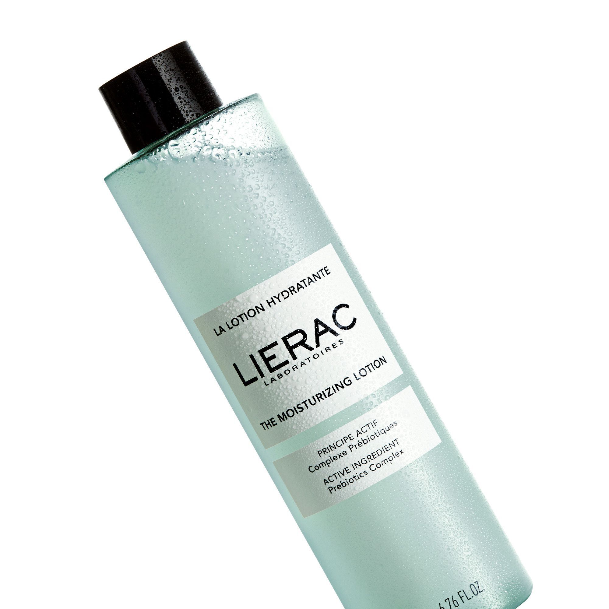 Een fles Lierac La Lotion Hydratante. Lichtgroene vloeistof in een cilindrische fles met zwarte dop. Opschrift: Lierac, La Lotion Hydratante.