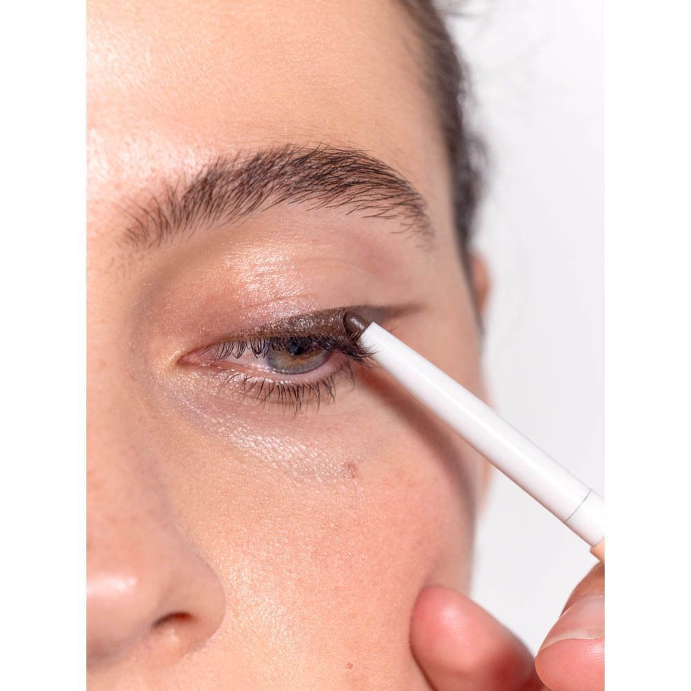 Oogpotlood wordt op oog aangebracht. Merk: Même. Opschrift: Le crayon pour les yeux, Eye pencil.