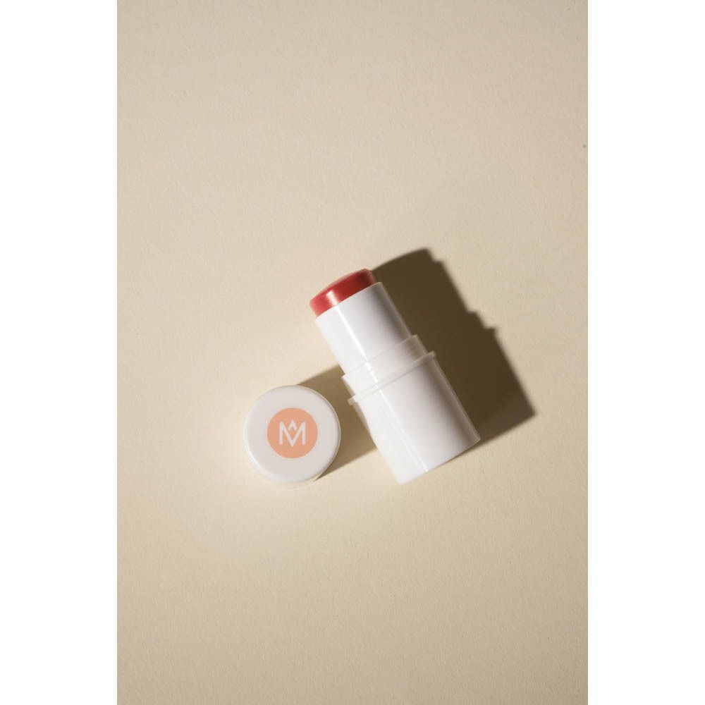 Witte stick met roze product en deksel met logo. Op beige achtergrond.