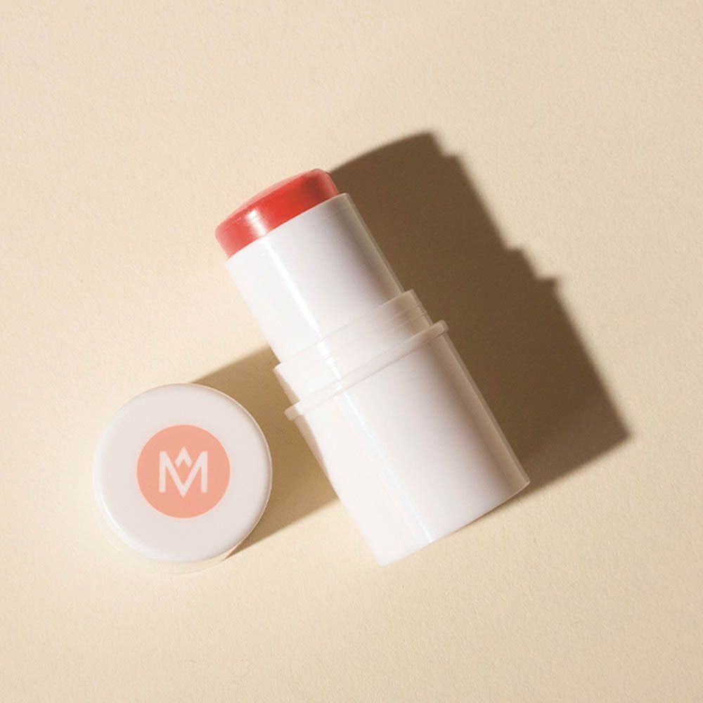 Stick blanc avec produit rose et couvercle avec logo. Sur fond beige.