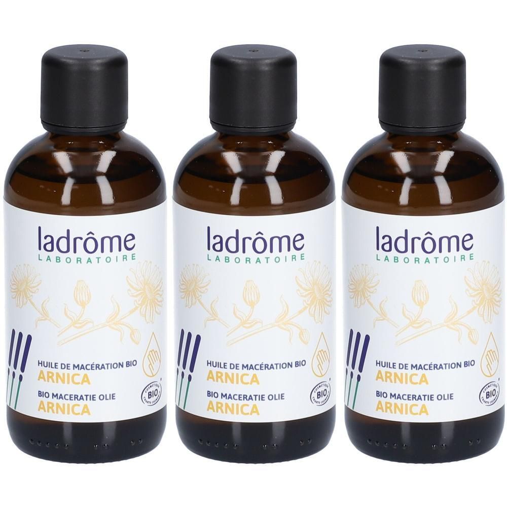 Drie bruine olieflesjes met zwarte dop en wit etiket. Opschrift: Ladrôme, Arnica.