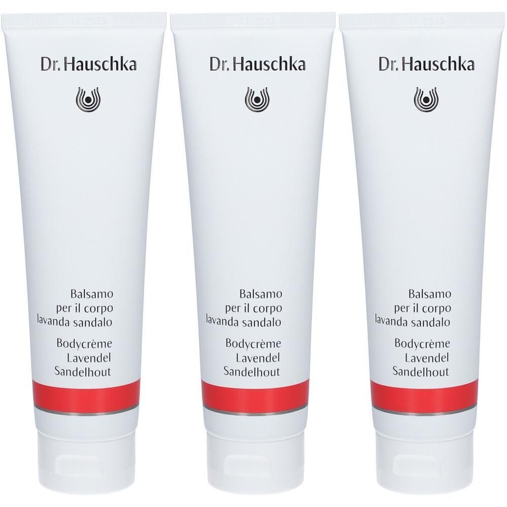 Trois tubes de crème pour le corps Dr. Hauschka. Tubes blancs avec bande rouge, texte noir et logo. Inscription : Lavande Bois de Santal.
