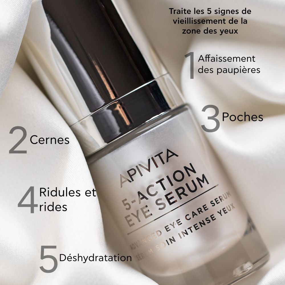 Apivita 5-Action Eye Serum sur tissu blanc. Inscription: 5-Action Eye Serum, Advanced Eye Care Serum. Marquage des 5 signes du vieillissement.