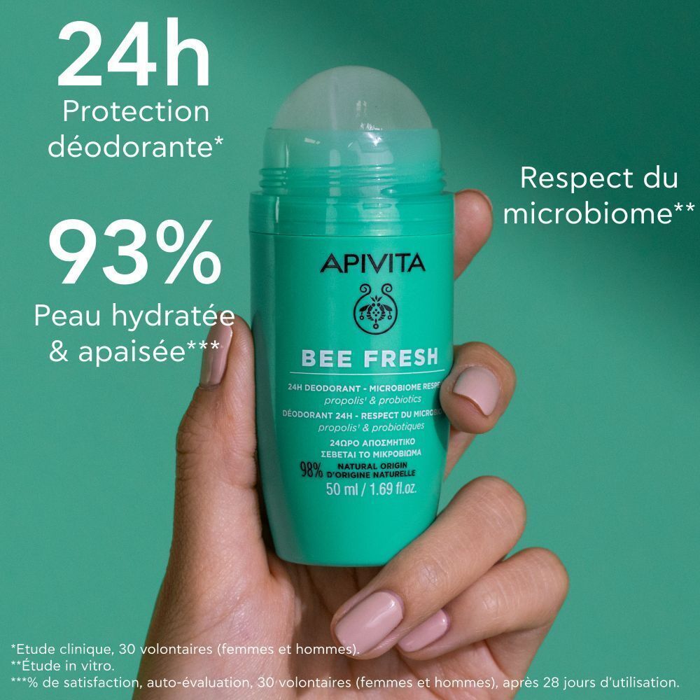 Une main tient un déodorant roll-on vert. Inscription : Apivita Bee Fresh, 24h Déodorant.