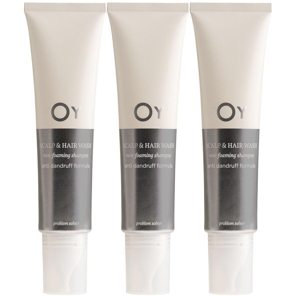 Drie tubes Oy Scalp & Hair Wash. Witte tubes met grijze etiketten. Bovenin "OY", daaronder "SCALP & HAIR WASH".