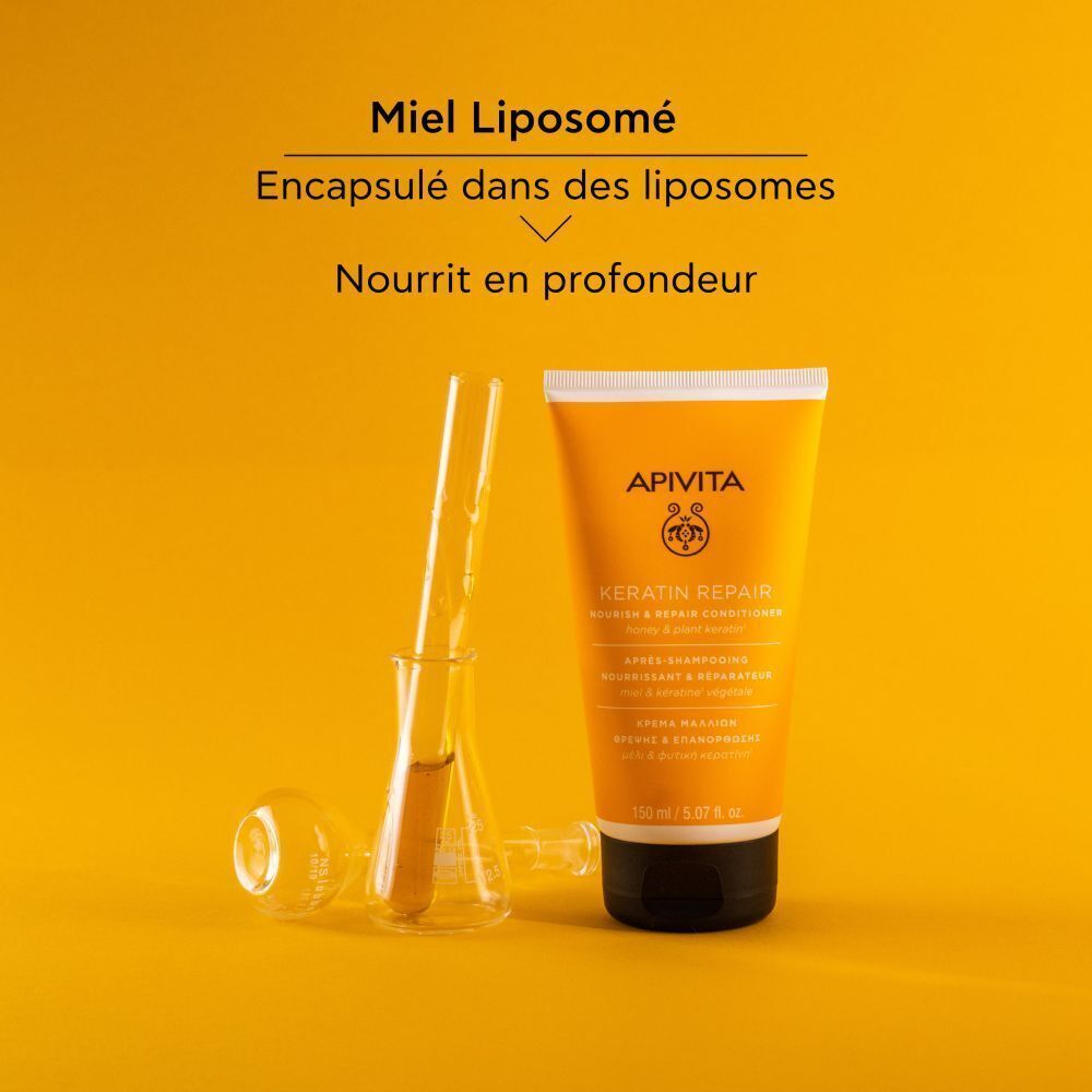 Tube de conditionneur jaune, tubes à essai. Inscription: Apivita, Keratin Repair. Fond orange.