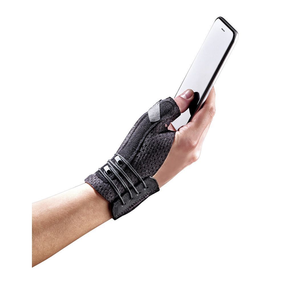 Attelle de Pouce Deluxe FUTURO™, noire, sur une main tenant un smartphone. Fermeture velcro et boucles.