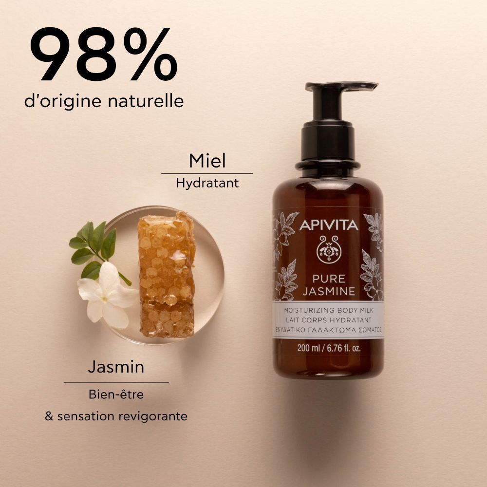Flacon Apivita Pure Jasmine Lait Corps Hydratant à côté d'un rayon de miel et d'une fleur de jasmin. Texte: 98% d'origine naturelle.