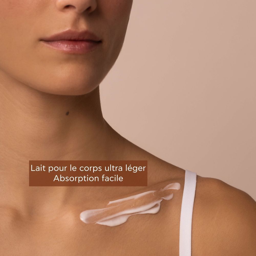Produit sur la peau. Texte: Lait pour le corps ultra léger, Absorption facile.
