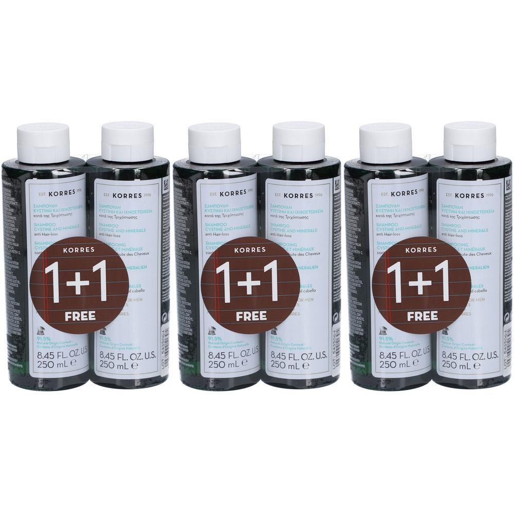 Meerdere shampoo flessen met witte doppen. Elke fles heeft een sticker met "1+1 GRATIS" en het merk Korres.