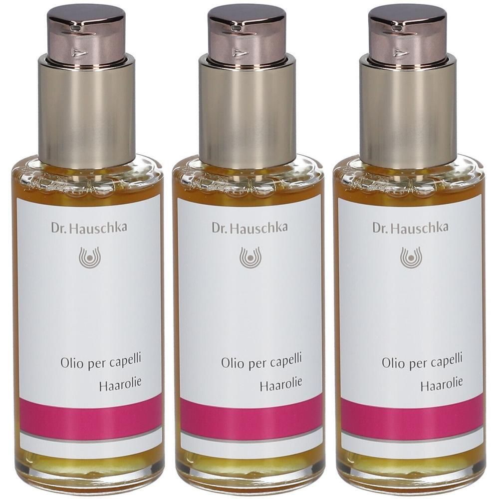 Trois flacons en verre avec pompes argentées. Étiquettes avec "Dr. Hauschka", "Olio per capelli Haarolie".