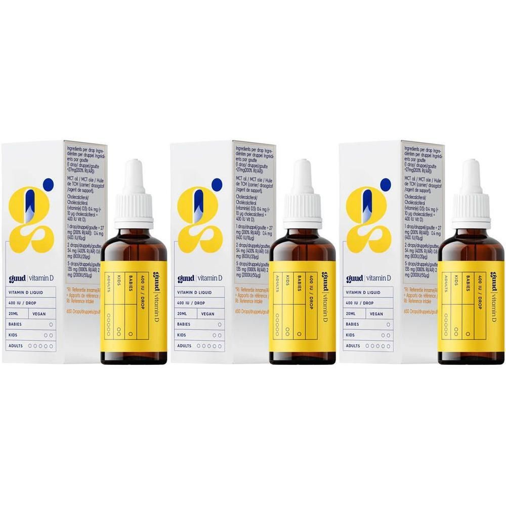 Meerdere flessen Guud vitamine D met verpakking. Bruine glazen flessen met witte dop en geel etiket. Witte dozen met logo.