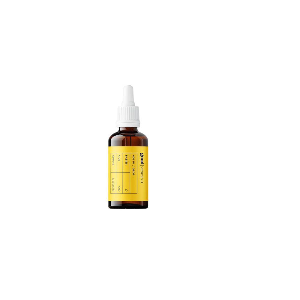 Een fles Guud vitamine D. Bruine glazen fles met witte dop en geel etiket.
