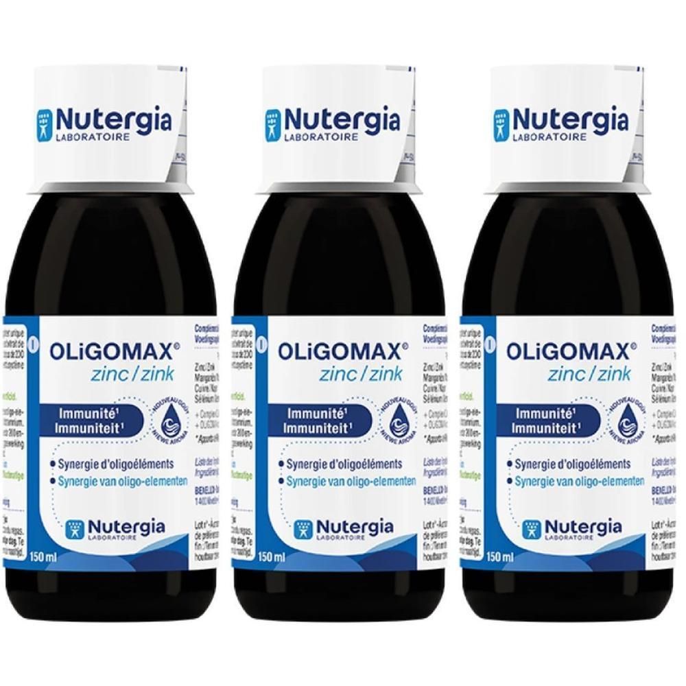 Drie flessen Oligomax Zink. Zwarte vloeistof in glazen flessen met witte etiketten. Opschrift: Nutergia, Oligomax, Zink, Immuniteit.