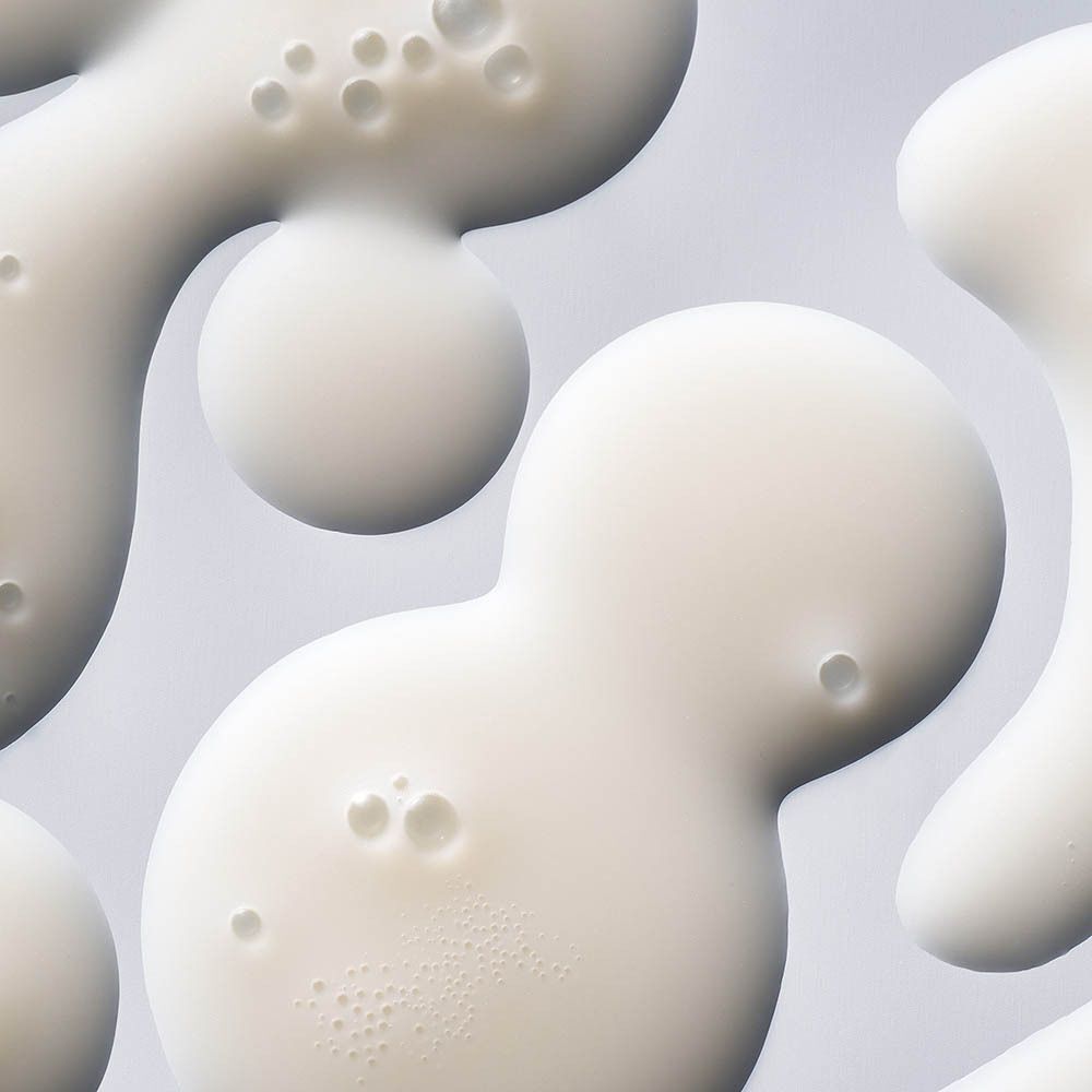 Close-up van witte, druppelvormige serumvlekken met belletjes.