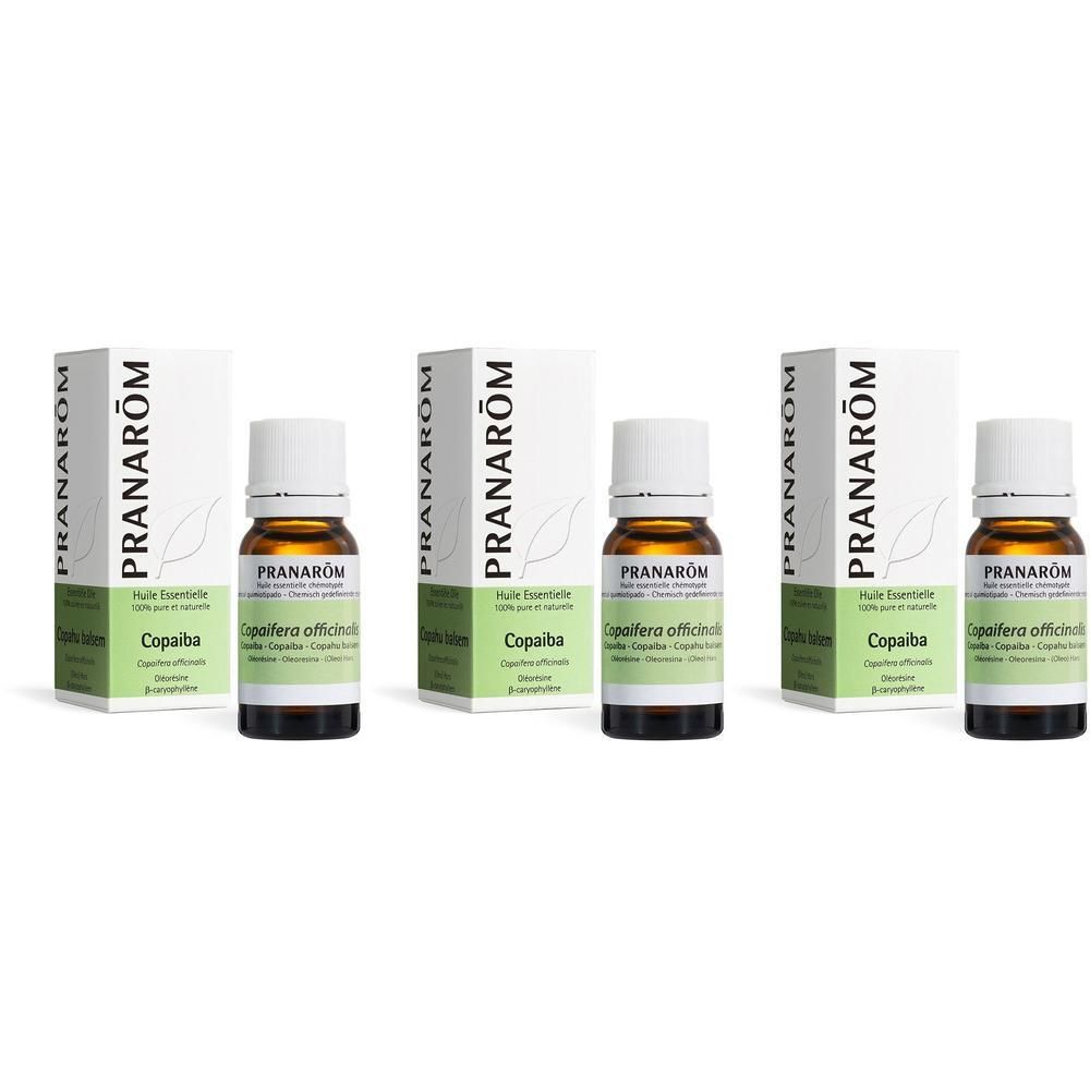 Drie flessen en verpakkingen. Op de verpakkingen staat "PRANAROM" en "Huile essentielle". Op de flessen staat "Copaiba".