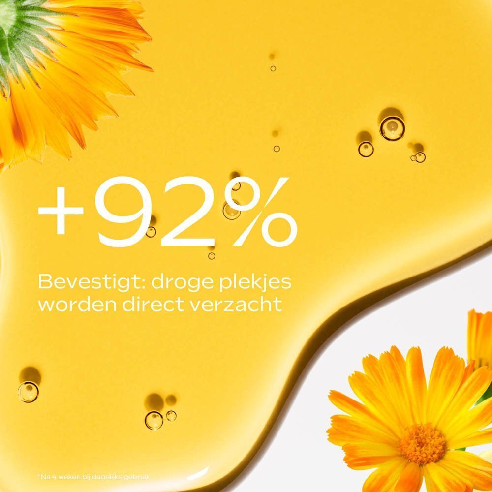 Close-up van gele vloeistof met bloemblaadjes. Tekst: +92%, Bevestigt: droge plekjes worden direct verzacht.