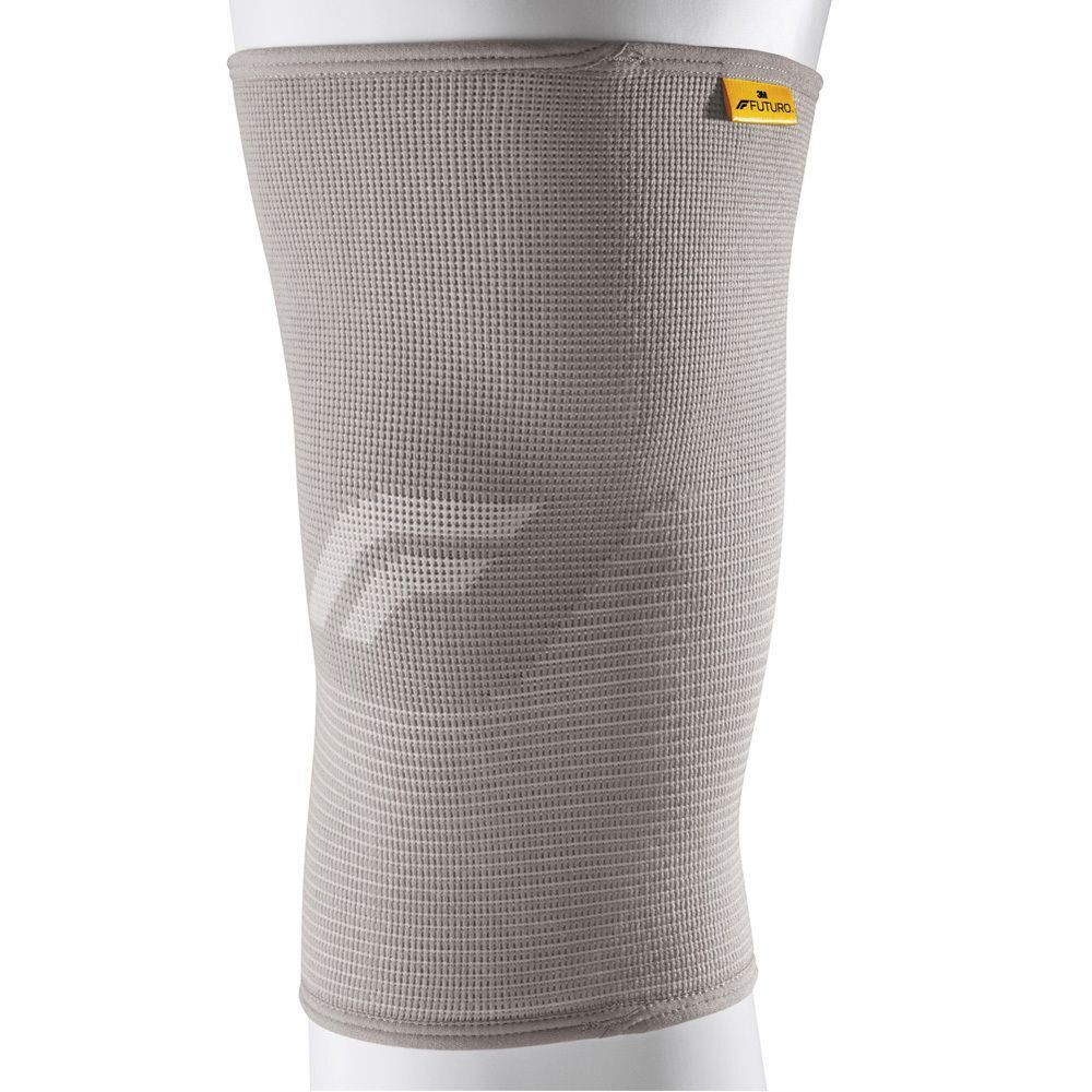 Bandage de genou FUTURO™ Comfort Lift gris sur une jambe. Logo FUTURO™ jaune. Forme anatomique.