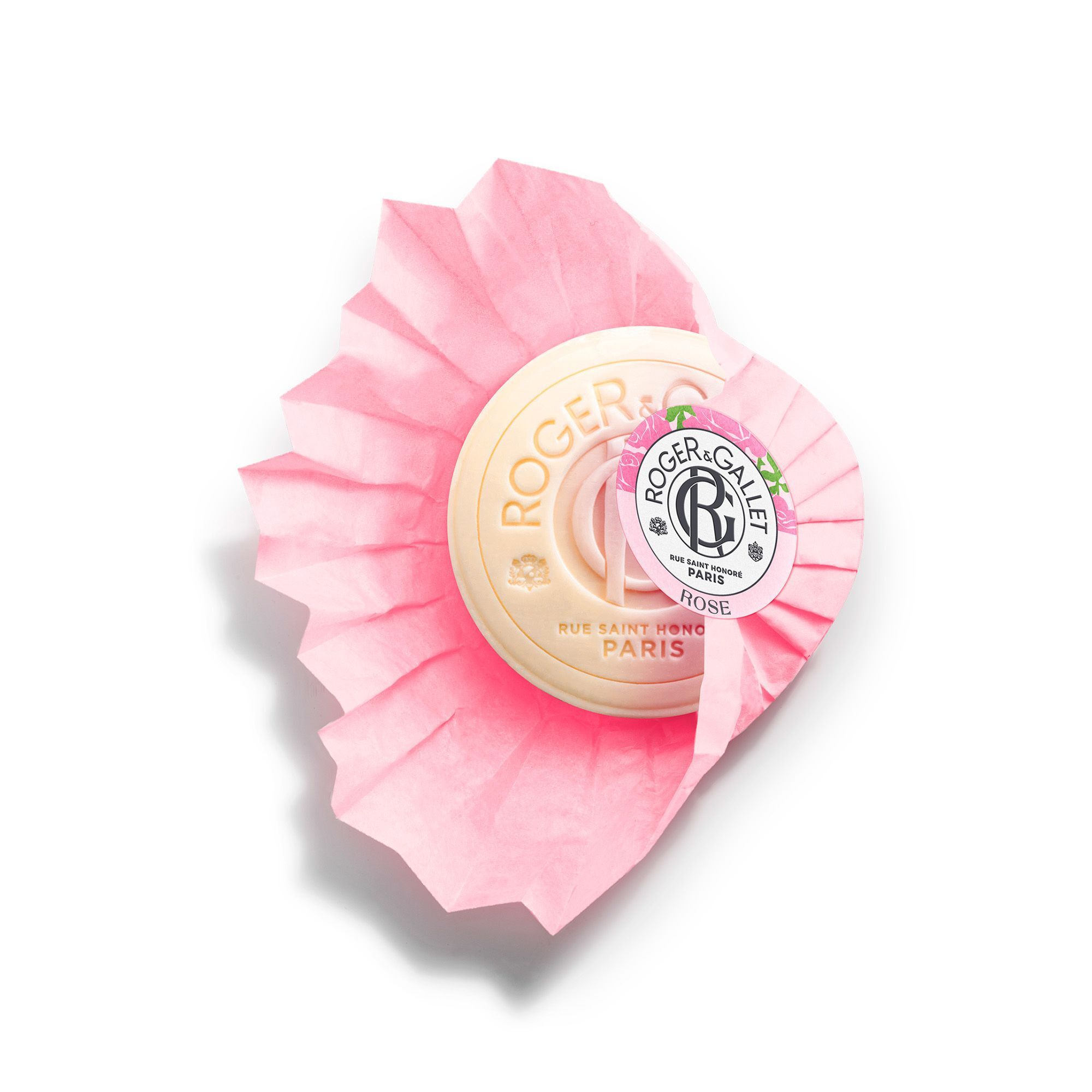 Ronde, crèmekleurige zeep op roze gevouwen papier. Opschrift: Roger & Gallet, Rose. Logo en tekst.