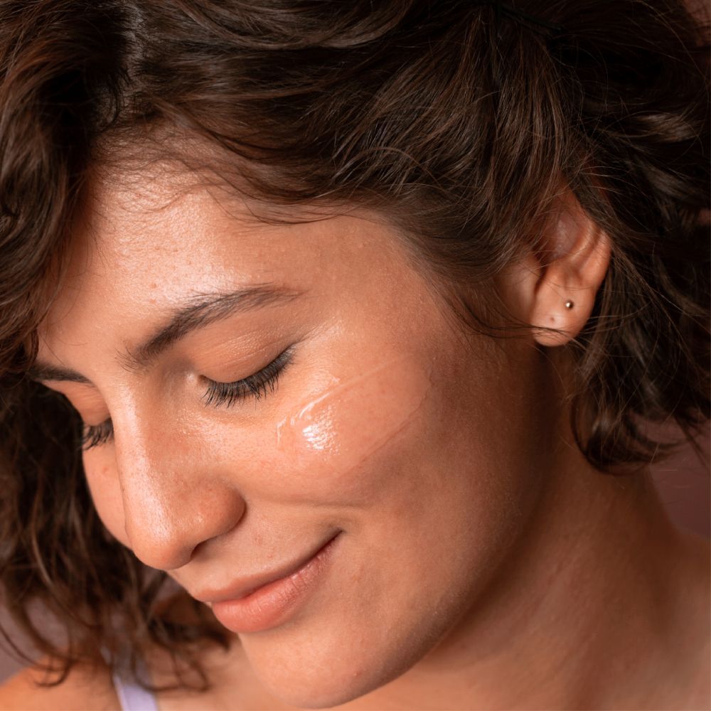 Vrouw met gesloten ogen die SVR Aqua-Gel Sensifine op haar huid aanbrengt. Product zichtbaar op de huid.