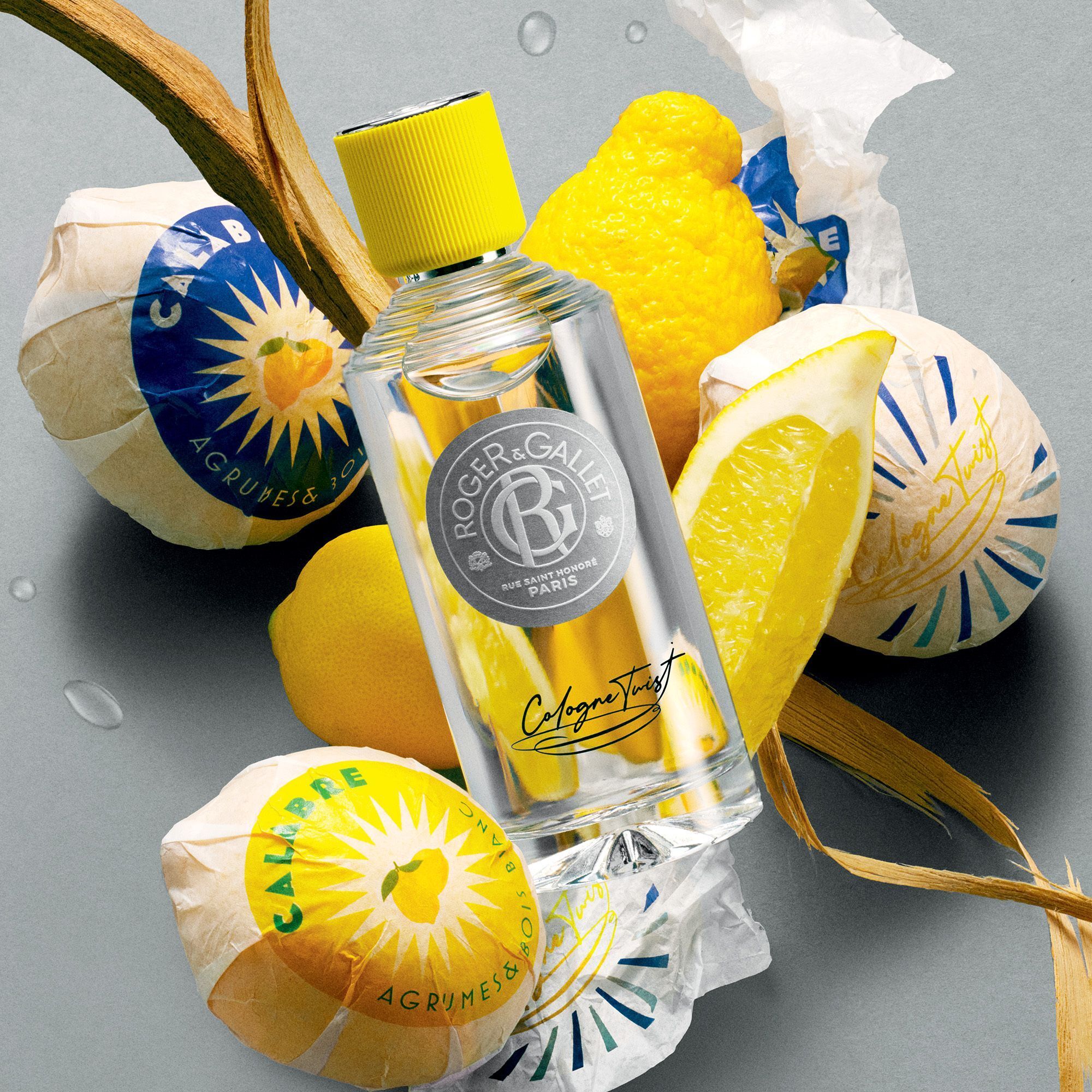 Flesje eau de cologne met gele dop, omringd door citroenen en zeep. Opschrift: Roger & Gallet.