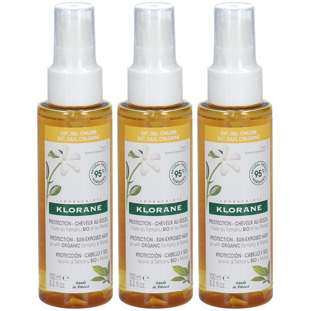 Drie spuitflessen met gele vloeistof. Opschrift: Klorane, bescherming voor de zon. Met Bio Tamanu en Monoi.