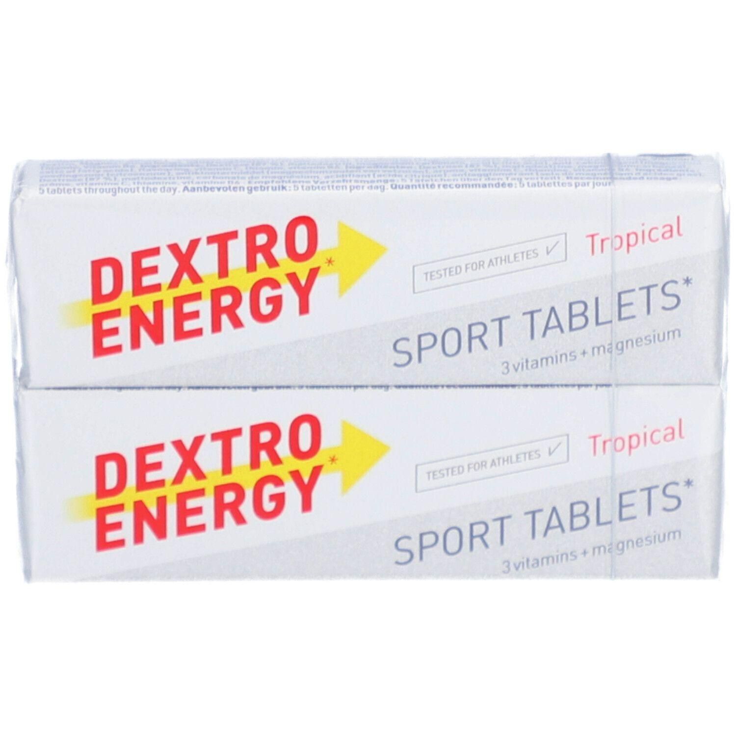 Twee verpakkingen Dextro Energy Sport Tablets Tropical. Witte verpakking met rode en gele tekst. Opschrift: Sport Tablets, 3 vitamines + magnesium.