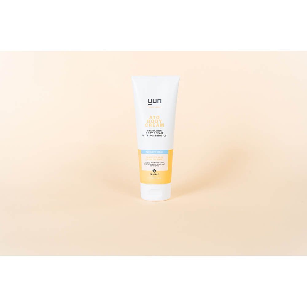 Een witte tube. Opschrift: YUN ATO CREAM. Beige achtergrond.