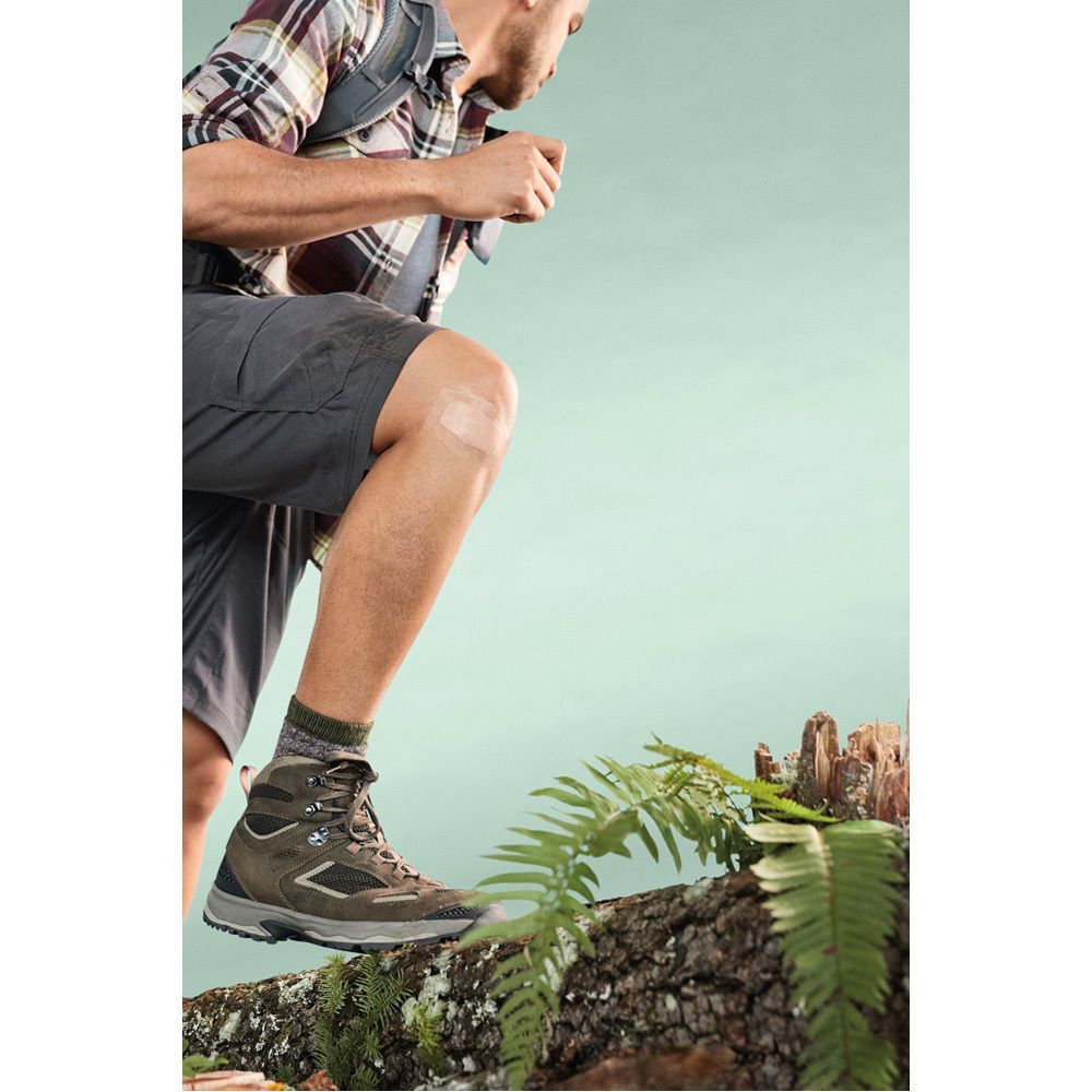 Persoon aan het wandelen. Nexcare Max Hold pleister op het been. Persoon draagt wandelschoenen.