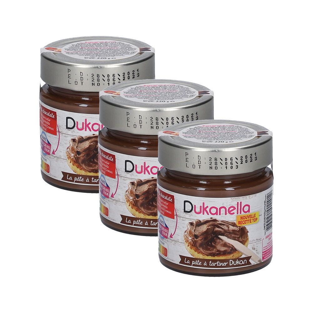 Drie potten Dukanella-spread. De etiketten tonen logo's en de productnaam. De deksels zijn zilverkleurig.