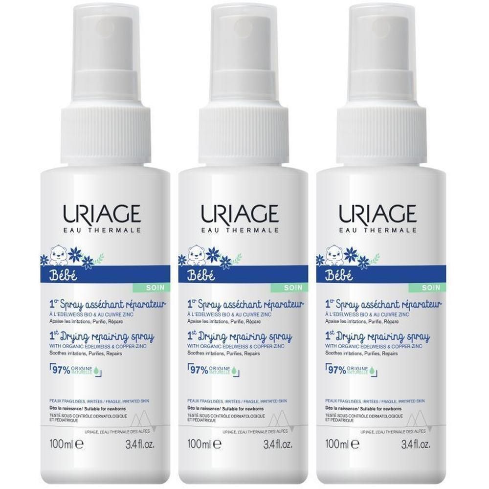 Drie witte sprays met labels. Opschrift: Uriage Bébé, 1er Spray asséchant réparateur, 100ml.