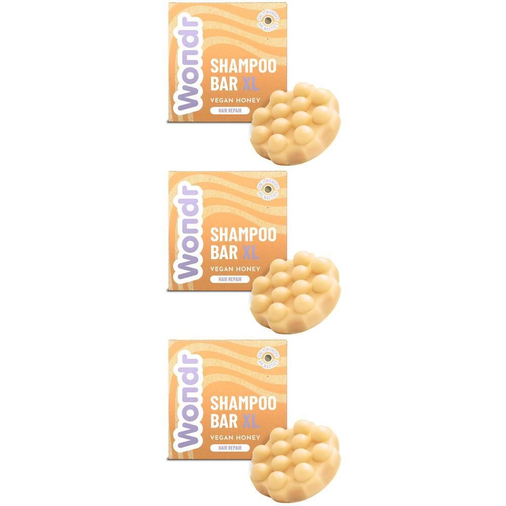 Drie shampoo bars en verpakkingen. De bars zijn lichtgeel, rond en hebben een noppenstructuur. De verpakkingen zijn oranje.