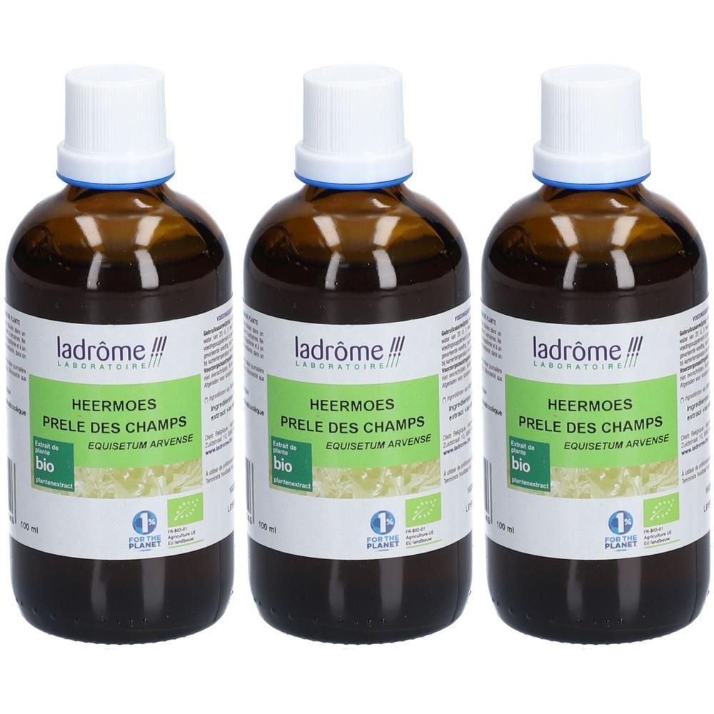 Trois flacons en verre brun avec bouchon blanc. Étiquette avec texte: HEERMOES, PRELE DES CHAMPS, certification bio et logo de la marque.