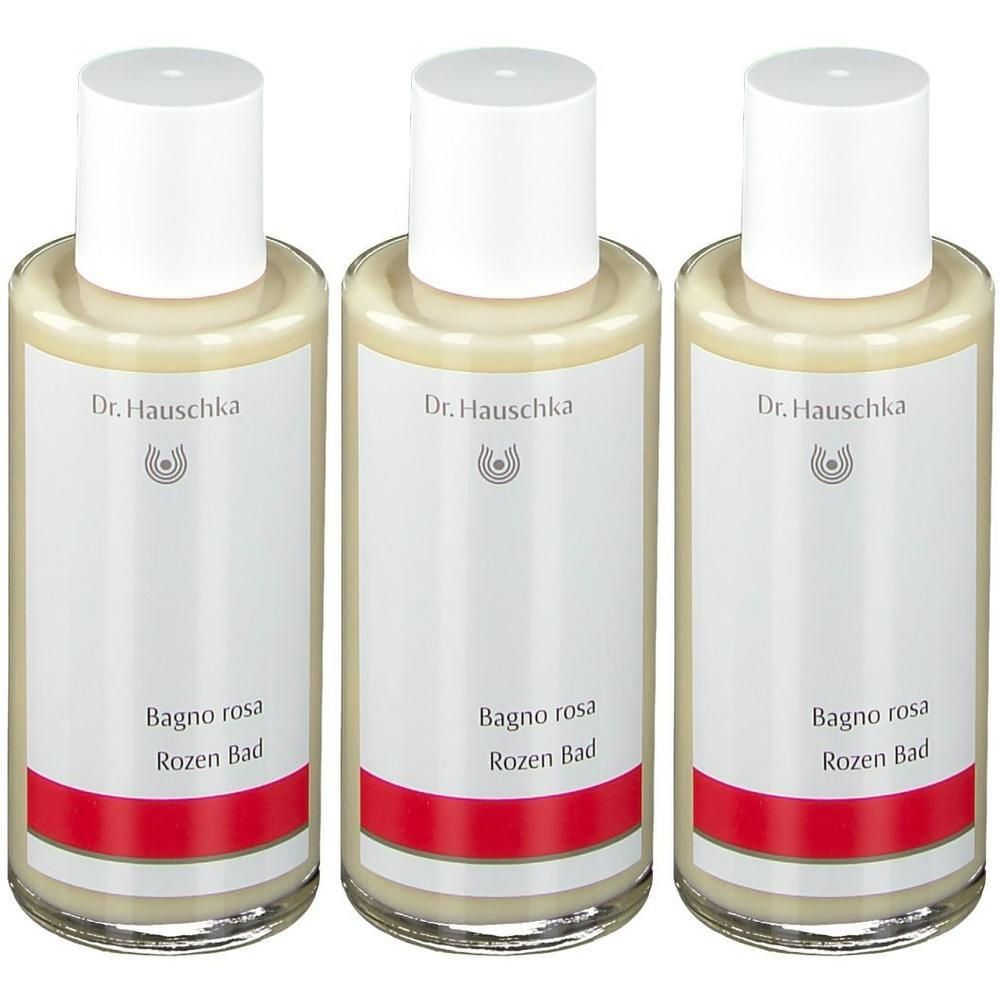 Drie flessen met witte dop en etiket. Opschrift: Dr. Hauschka, Bagno rosa, Rozen Bad. Rode streep.