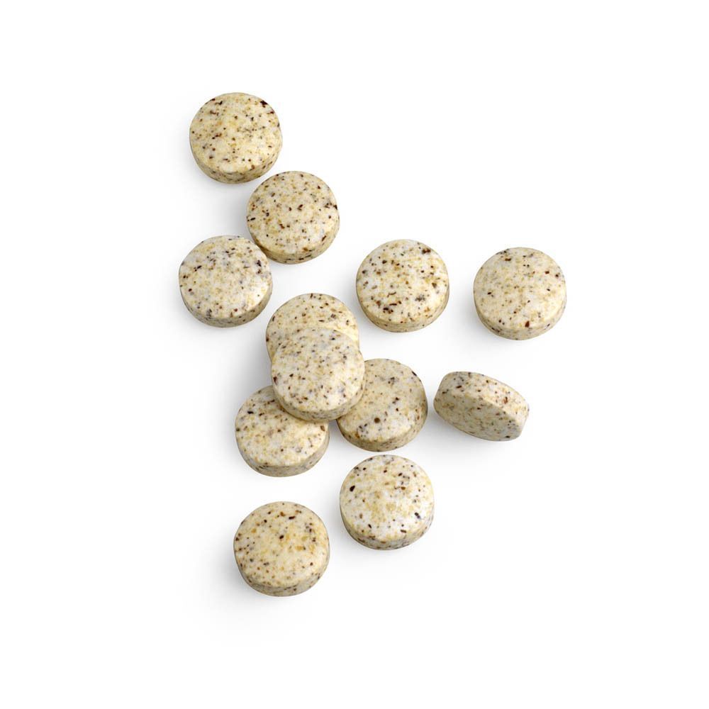 Tien tabletten, Biotics Research Mo-Zyme, met donkere stippen. Ronde vorm, lichte kleur. Op witte achtergrond.