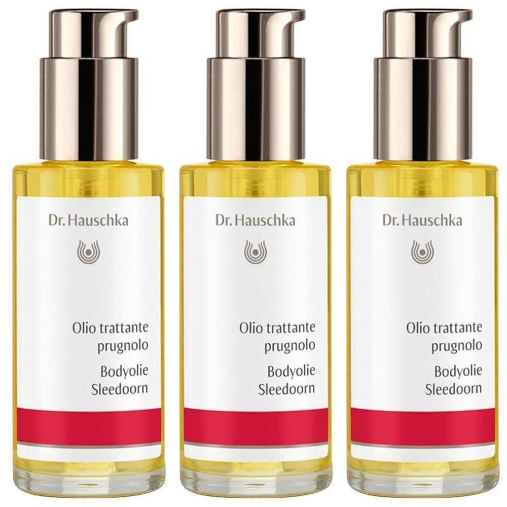 Drie flessen gele olie. De etiketten tonen "Dr. Hauschka" en "Olio trattante prugnolo Bodyolie Sleedoorn".