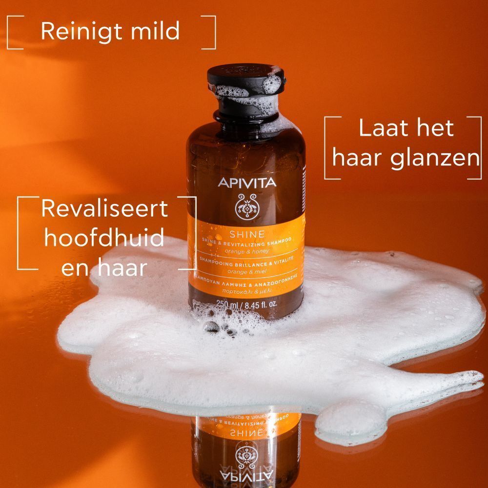 Apivita Shine Shampooing Brillance & Vitalité fles op schuim. Tekst: Reinigt mild, Laat het haar glanzen, Revaliseert hoofdhuid en haar.