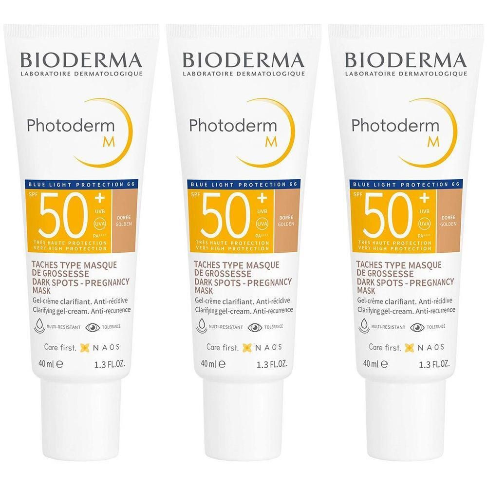 Trois tubes de Bioderma Photoderm M Gel-Crème Clarifirant Doré SPF50+. Tubes blancs avec accents jaunes et bruns. Texte : 50 SPF, Taches.