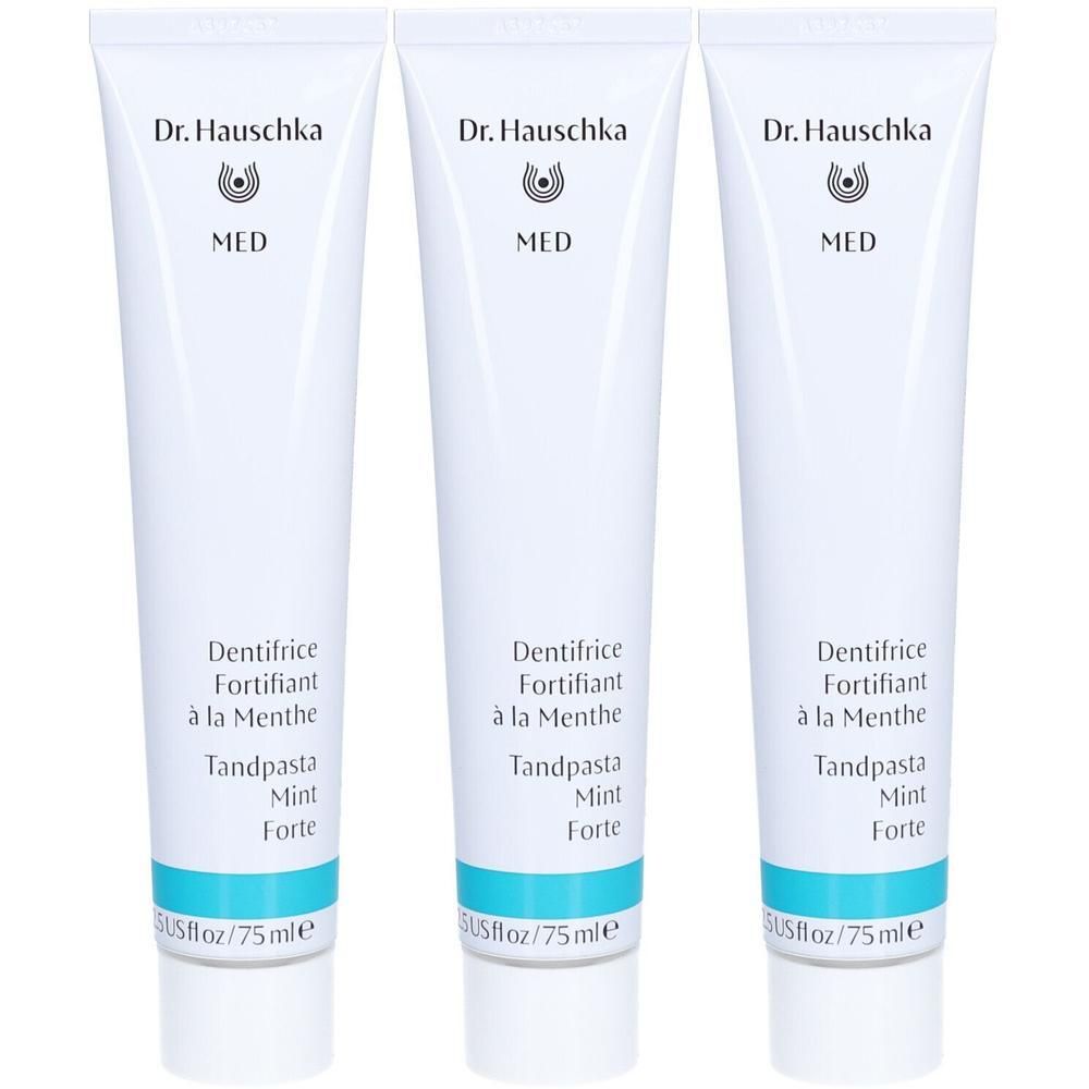 Trois tubes de dentifrice. Tubes blancs avec texte bleu et logo. Inscription: Dr. Hauschka MED Dentifrice Fortifiant à la Menthe.
